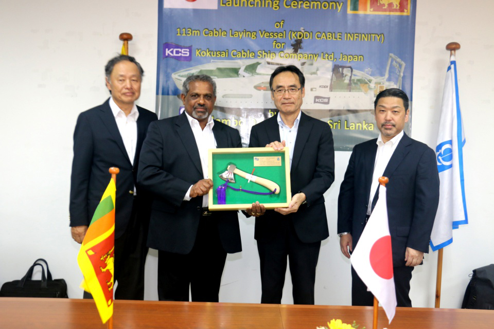 Mr. D.V. Abeysinghe MD/CEO Colombo Dockyard PLC presenting the symbolic axe used to launch the Cable Laying Vessel “KDDI CABLE INFINITY”, flanked by Dr. Toru Takehara Chairman CDPLC and Mr. Yukihiro Fujii Managing Director KCS